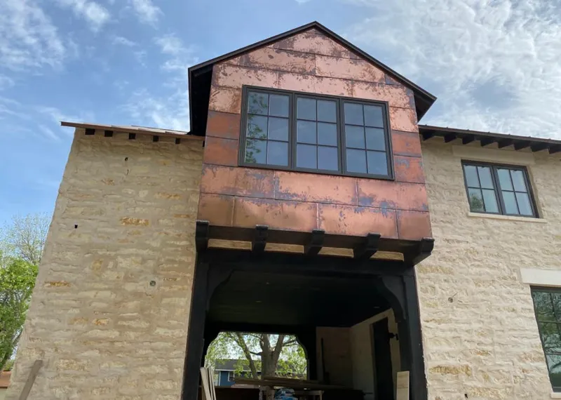 Copper metal panel facade on a stone building for Roof Repair in Muskego
